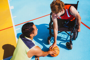 latin young man using wheelchair and playing basketball with a friend in Mexico, disabled people