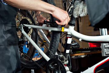 Fototapeta premium Bicycle lunch and knitting needles close up. Bicycle maintenance and service. Bicycle wheel repair. Male hands of a master close up.