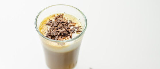 Coffee drink shot with a nutty note with fluffy milk foam, decorated with chocolate shavings