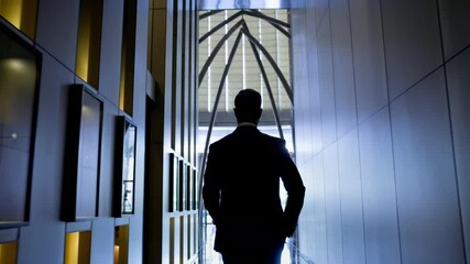 Stylish Young Man Walks Down The Hotel Corridor. He Is Dressed In Suit. View From The Back.