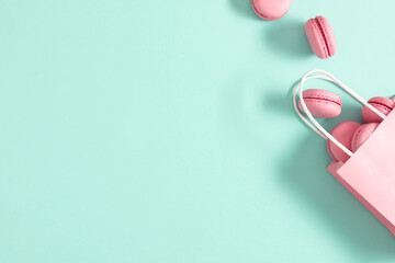 Pink macaroons on mint background. Sweet pastries background. Flat lay, top view, copy space