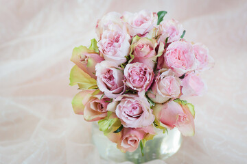 Rusty pink roses wedding bouquet in soft background