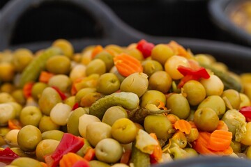 Green olives with carrots and gherkins in bulk, food concept