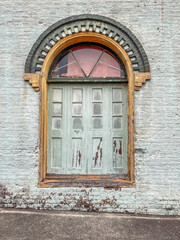Worn doors on brick building with decorative brick arch