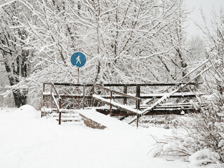 in winter, the snow-covered sign is blue against the cold