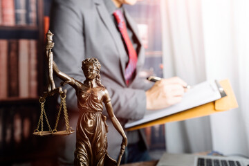 Justice and law concept.Male judge in a courtroom with the gavel, working with, computer and...