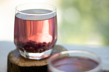 Red compote with cherry, strawberry, gooseberry nd raspberry on wooden table, close up