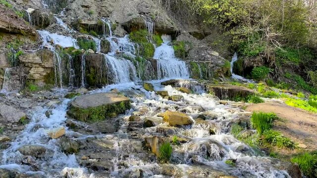 Little stream in the forest, small forest river waterfall summer spring time. Clear pure water. Sunny day. 