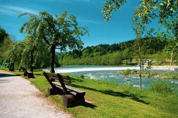 wooden bench on the river bank in Mozirskij Gaj park Slovenia. - obrazy, fototapety, plakaty