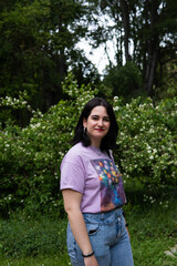 Fototapeta premium Photo of an attractive woman with black hair in the middle of nature during spring time, walking around and smiling during a sunny day