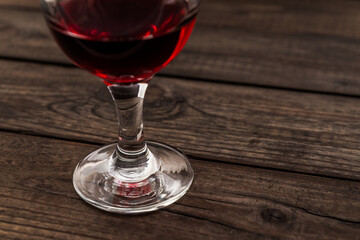 Glass of red wine on an old wooden table. Close up view