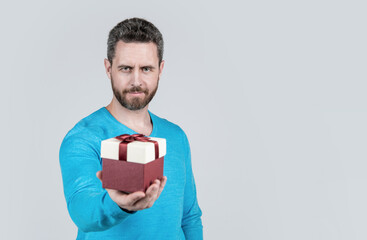 handsome mature man with beard taking present box, selective focus and copy space, shopping