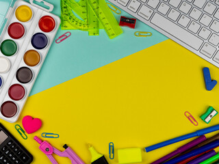 School supplies on a bright yellow and magenta background. Copy Space. Stationery on a yellow table. School concept. Back to school. Paints, pencils, rulers and other school items for study