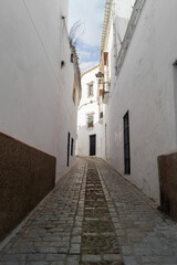 Narrow sloping street with white walls in Carmona (Seville, Spain). Typical street of the villages of Andalusia with Mediterranean style.