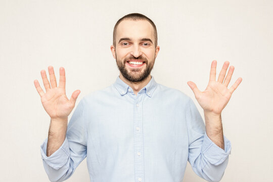 Happy bearded shows hands up, white background