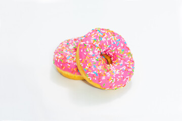 Two pink donut with bright sprinkles, white background, side view, copy space