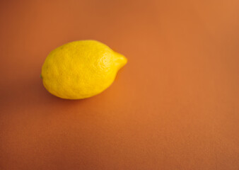 Yellow lemon on a pastel color. Minimalist depiction of fruit. Self-care and vitamin c to boost immunity.