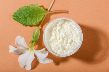 Dried Royal jelly powder on orange background.