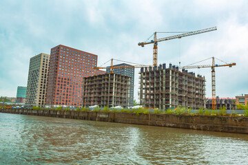 Residential buildings on the banks of Moskva River on a cloudy day. Housing construction according to the city renovation program. Moscow, Russia
