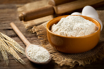 Bowl with wheat flour on the table.