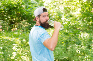 Naklejka na ściany i meble daily water. brutal bearded man drink bottle. mature hipster with beard in forest.
