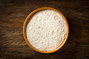 Bowl with wheat flour on the table.