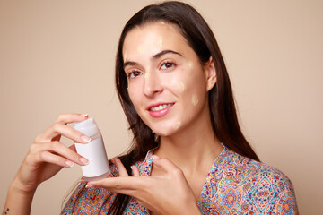 joven mujer latina mexicana con crema facial humectante spa