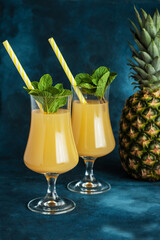 Pineapple fresh juice drink in glasses and ripe pineapple fruit