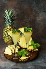 Tropical composition with pineapple and juice in glasses