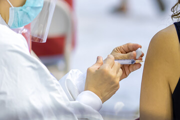 Doctor with face mask, holding syringe before make Covid-19 or coronavirus vaccine in hospital . Virus protection. COVID-2019 concept.