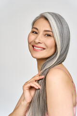 Vertical portrait of gorgeous happy joyful middle aged mature cheerful asian woman, senior older 50s gray haired lady isolated on white. Ads of aesthetic medicine spa salon hair care.