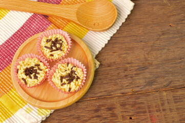 Malaysian homemade cookies called as Kuih Sarang Semut with chocolate rice on wooden plate served during Eid Fitri.