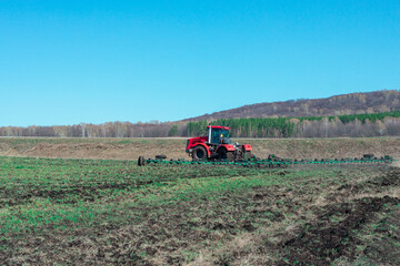 Obraz premium Field cultivation with a tractor in the spring.