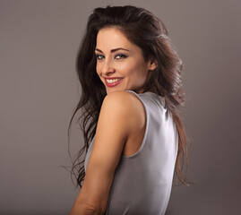 Fototapeta premium Beautiful happy toothy laughing woman with bright makeup on grey background with empty copy space. Closeup beauty