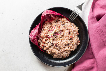 Italian risotto with red radicchio from Treviso, pancetta and taleggio cheese.  Top view. Light background.