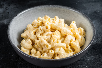 Mac and cheese american macaroni pasta with cheesy Cheddar sauce. Black background. Top view