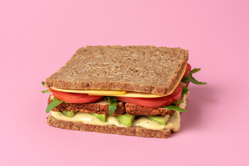 Vegan sandwich isolated on pink background. Plant-based food.