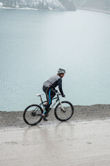 person riding a bicycle over mountain lake