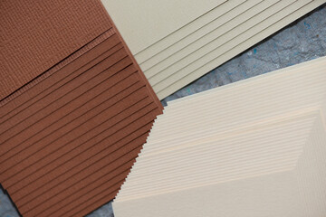 hazel brown and beige cut craft paper piled in a stepped pyramidal manner - photographed from above with a macro lens on grey