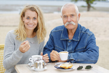 dad and his daughter having breakfast outdoors