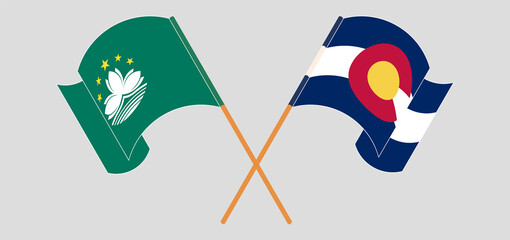 Crossed and waving flags of Macau and The State of Colorado
