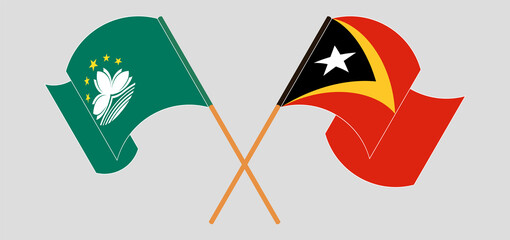 Crossed and waving flags of Macau and East Timor