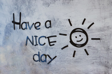 Have a nice day inscription and smiling sun made by stickers on the gray concrete wall. Positive...