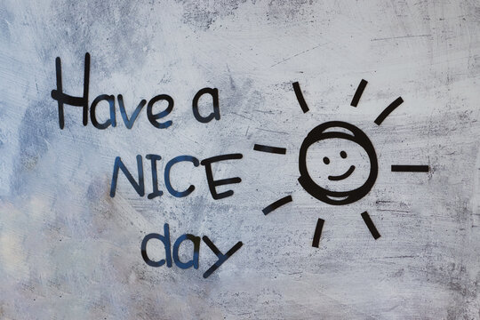 Have a nice day inscription and smiling sun made by stickers on the gray concrete wall. Positive minding concept. Selective focus.