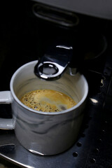 cup of fresh coffee in the coffee machine 