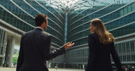Cinematic shot of happy smiling business colleagues in formal apparel are walking satisfied with their work after leaving the offices. Concept of corporate, company, success, cooperation, teamwork. - Powered by Adobe