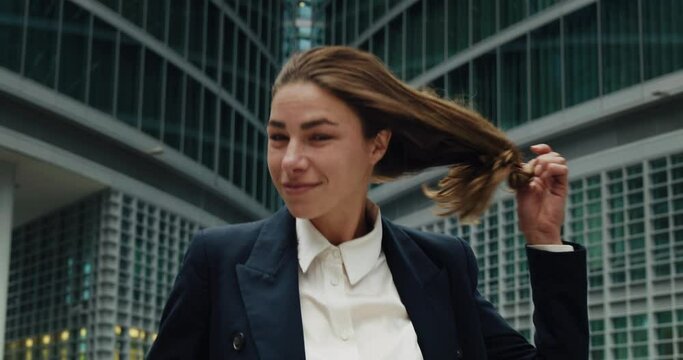 Cinematic shot of happy carefree business woman untie ponytail and tossing bunch of documents after hard working day while leaving office.Concept of corporate, success,business, finance, female career
