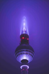 Scenic View Famous Alexanderplatz TV Tower of Berlin, Germany in Modern Futuristic Purple Light Color surrounded by Fog at Night, Close up View of Antenna