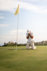 Angry golfer lamenting for missing his shot on the green a few inches from the hole.