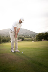 Golfer hitting ball on the green towards the hole